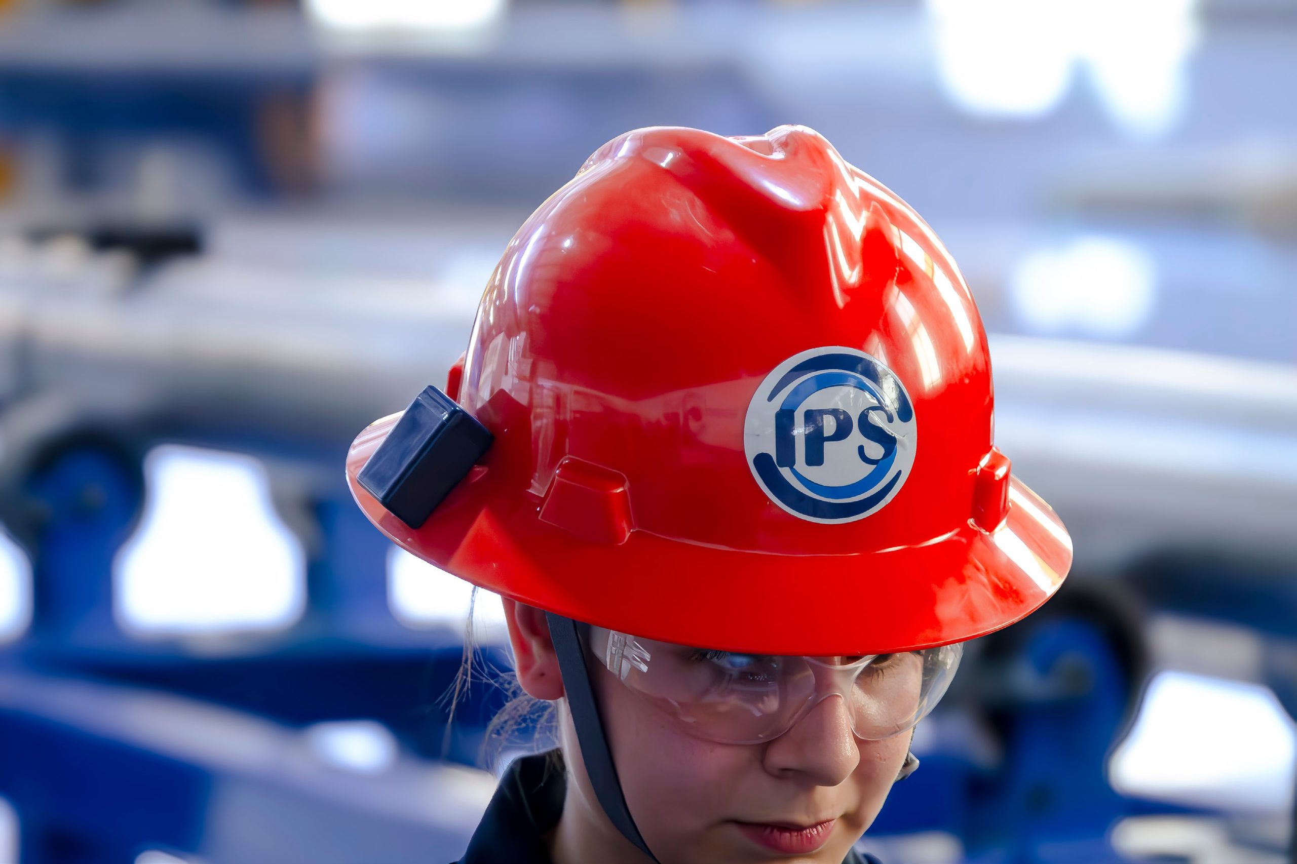 Grupo IPS technician wearing a red hard hat and safety glasses