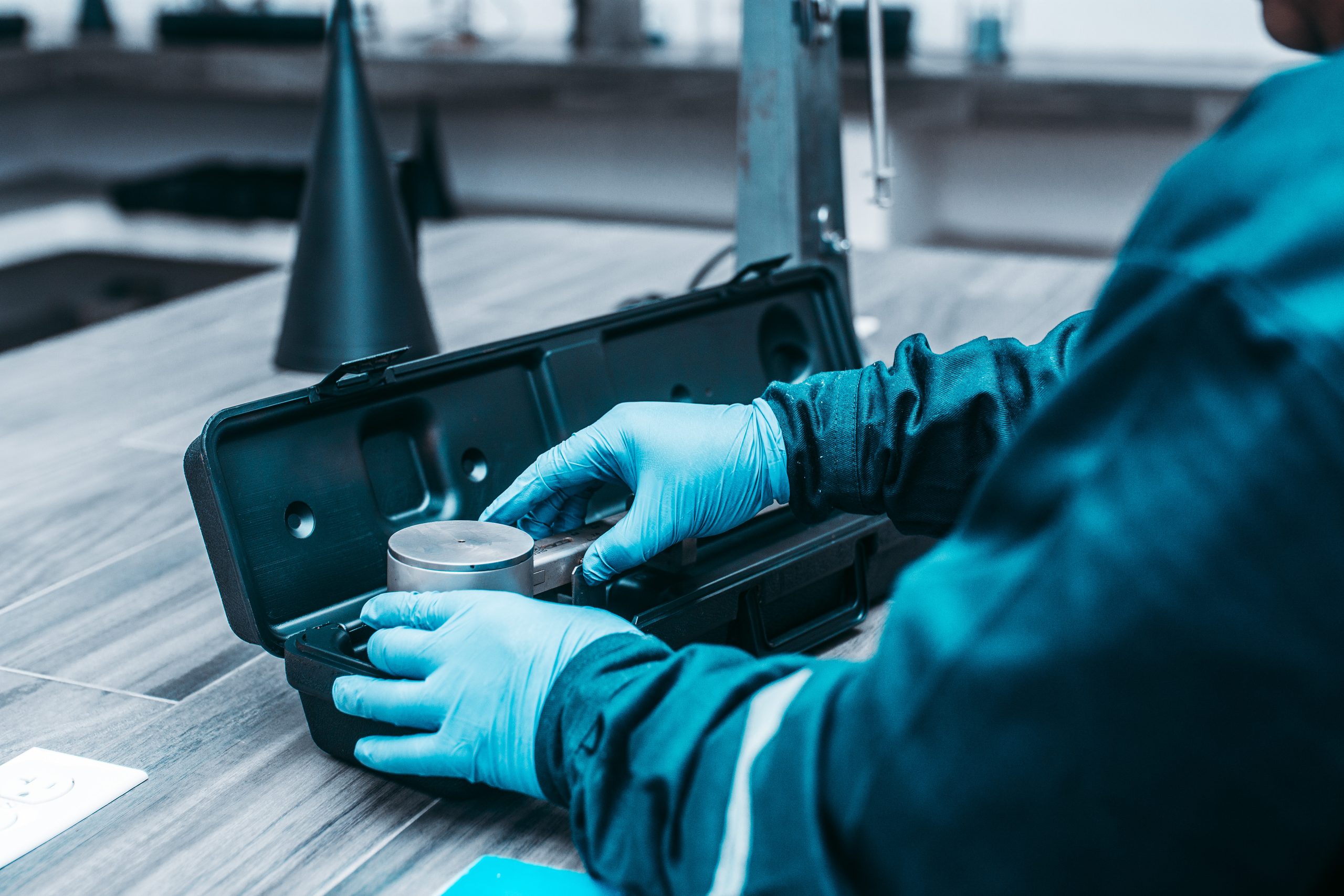 Gloved hands placing a sample cell into an equipment case