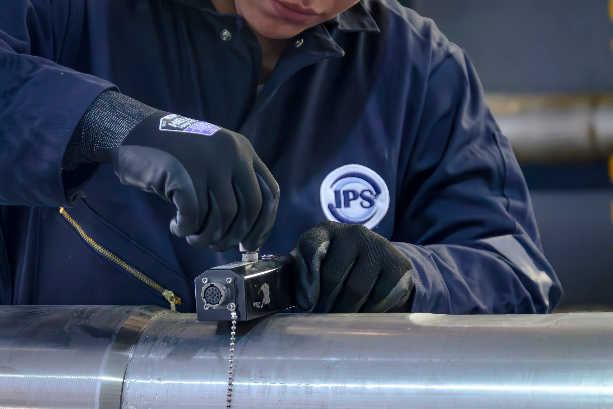 Grupo IPS technician measuring a downhole tool with a precision gauge
