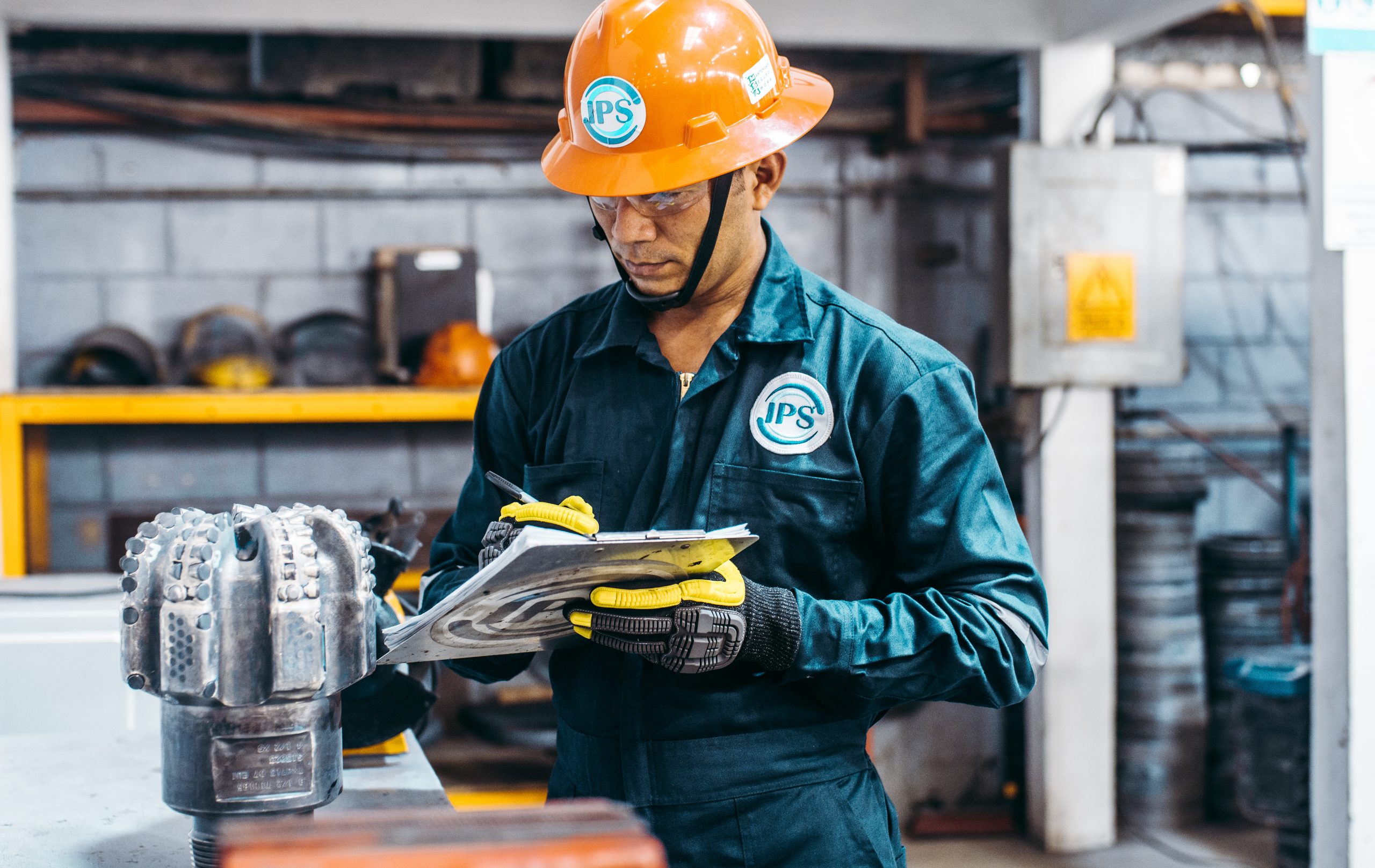 Engineer reviewing PDC bit documentation in the workshop