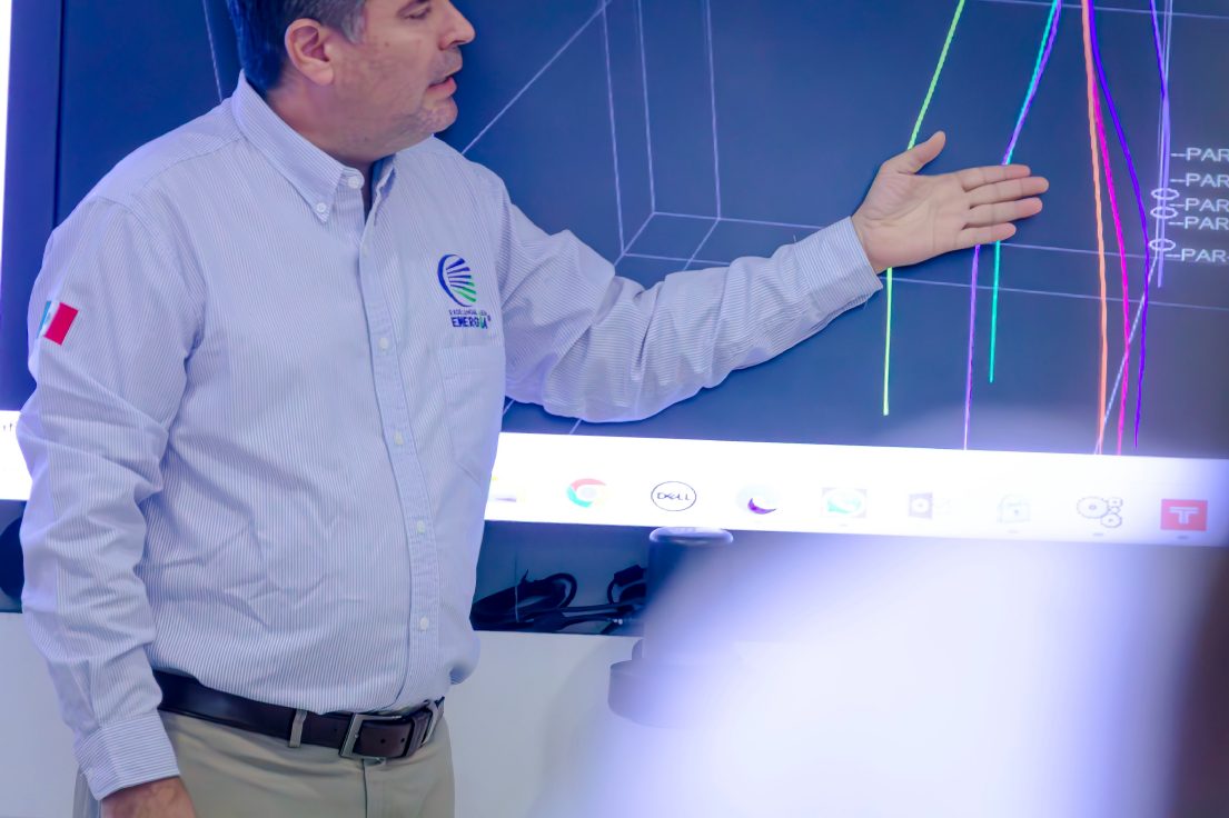 Engineer pointing at a well design on a large screen