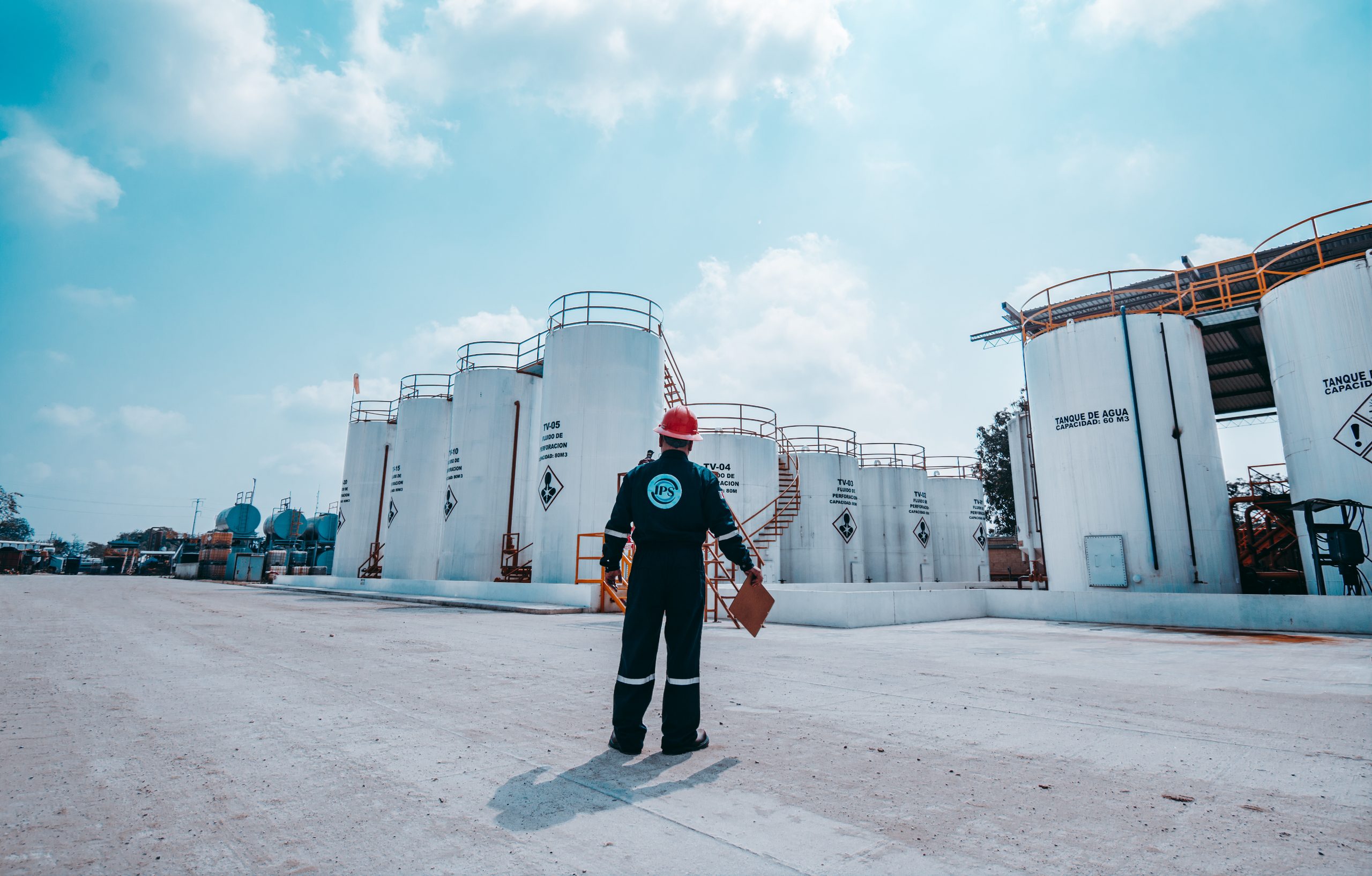 Technician inspecting storage tanks at a production facility