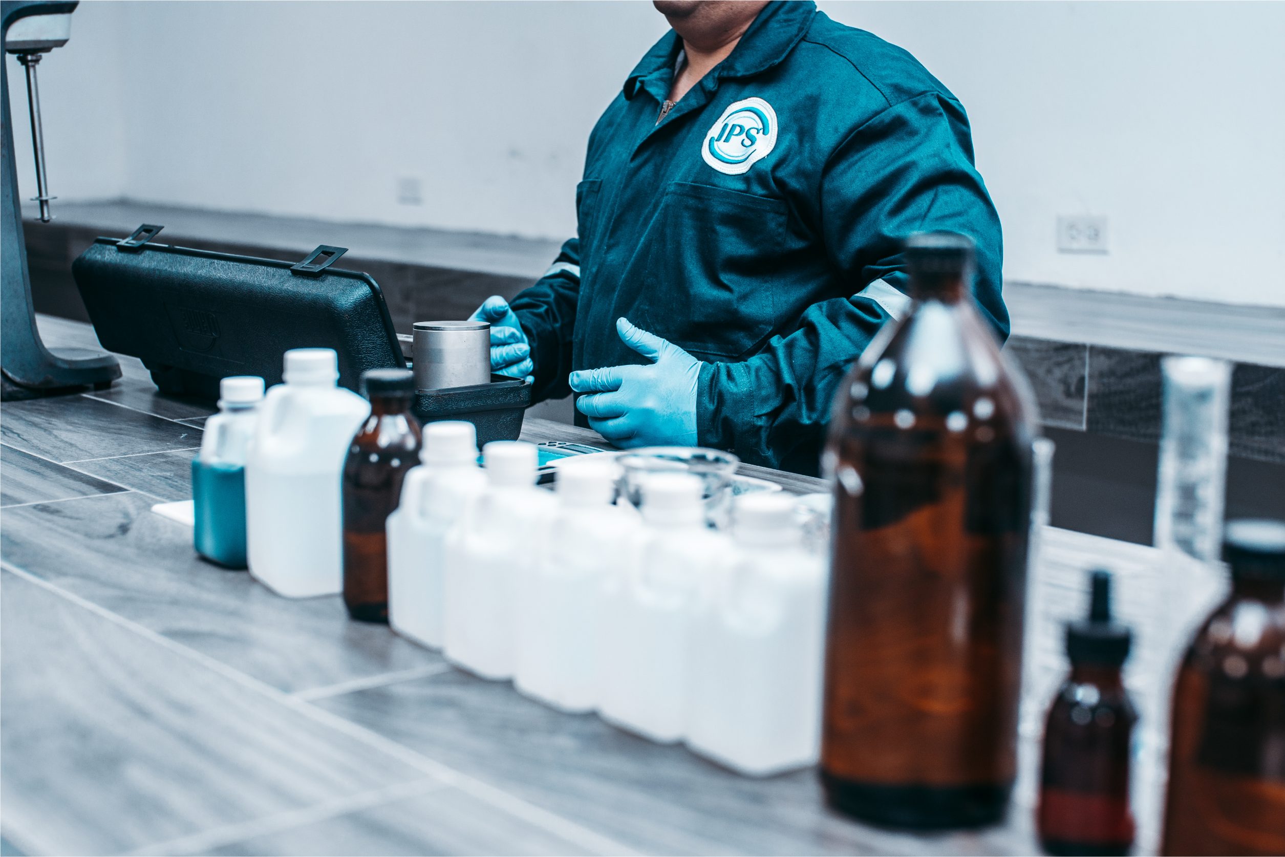 Technician handling product bottles on a laboratory bench